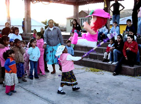 Tarahumara children try to break the Christmas piñata.