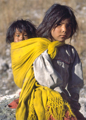 A young Tarahumara girl carries her little sister, in Mexico’s Copper Canyon.