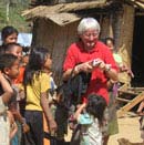 Tourist shows pictures to village children in Laos